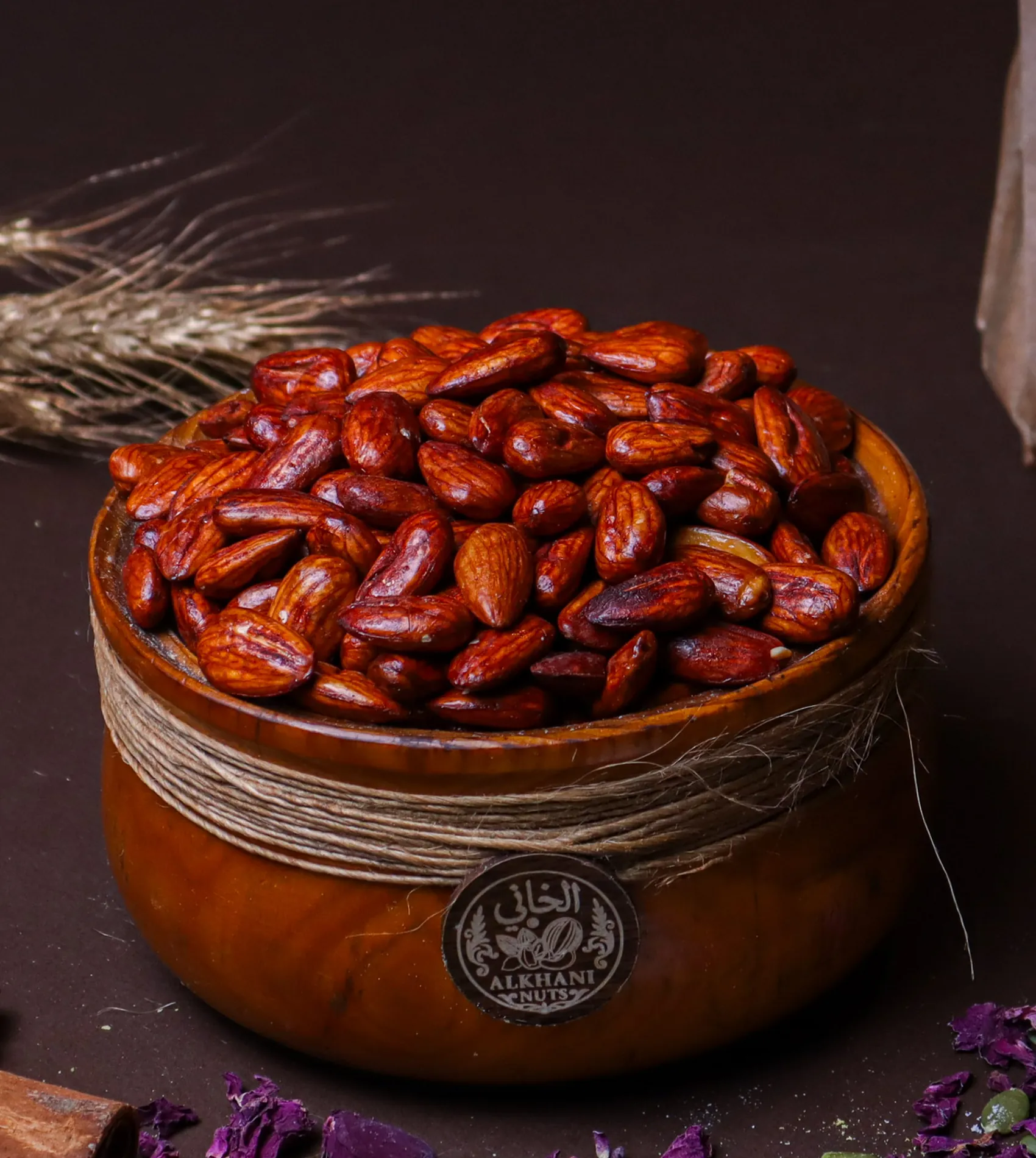 لوز أحمر، حبات كاملة لمّاعة لونها أحمر غامق، بزبدية خشب ملفوفة بخيط خيش وعليها ختم الخاني