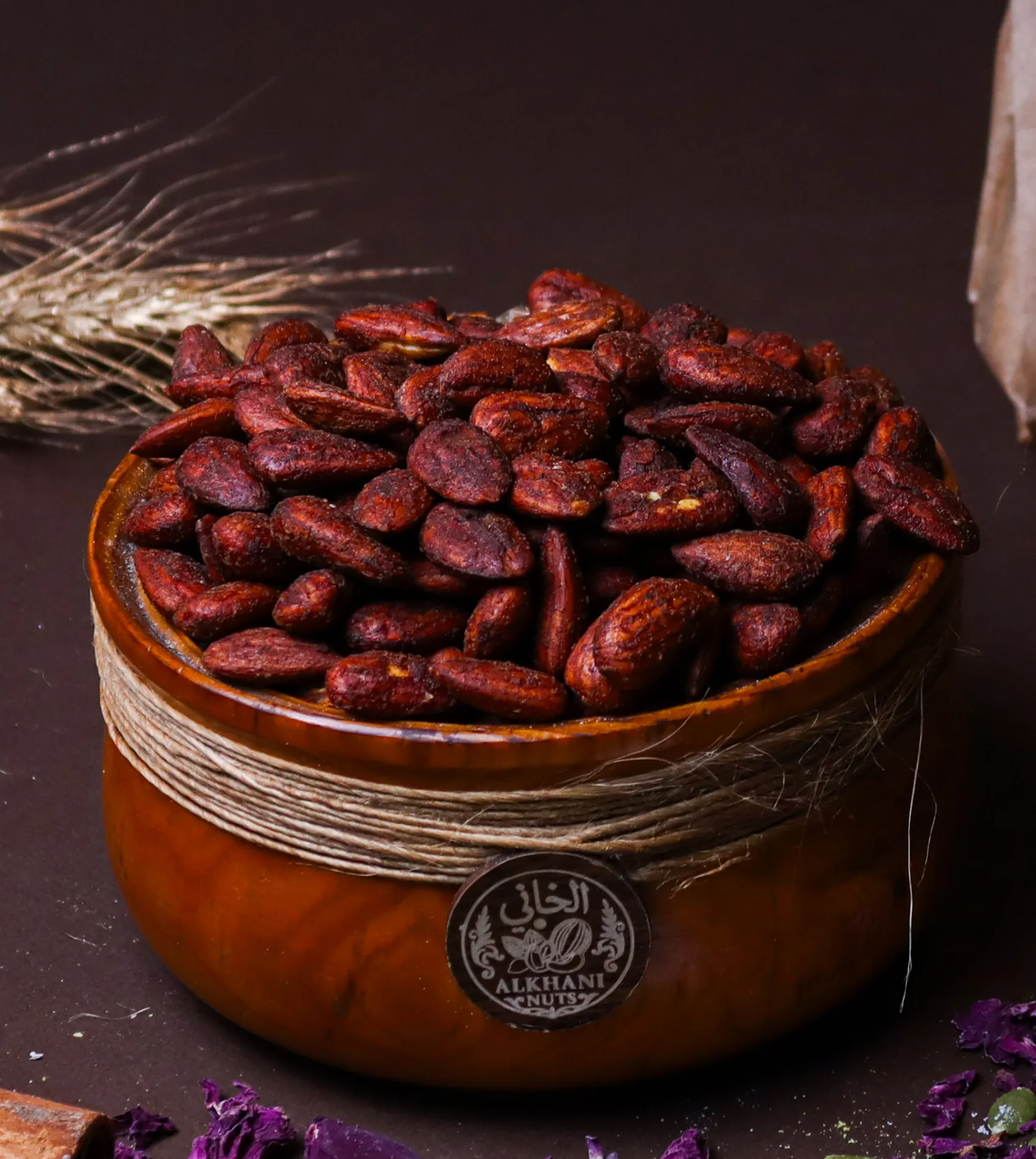 لوز مدخّن، حبات كاملة بني غامق مايل للخمري، بزبدية خشب ملفوفة بخيط خيش وعليها ختم الخاني