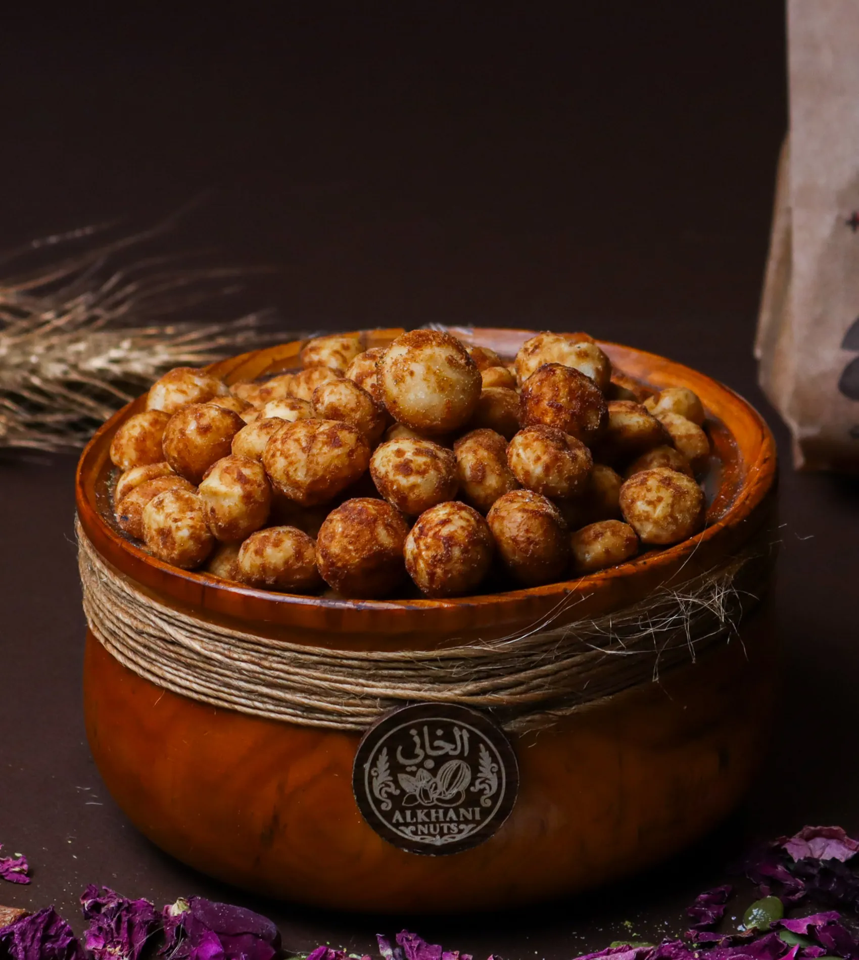 بندق محمّص، حبات مدوّرة كريمية عليها بقع بنية، بزبدية خشب ملفوفة بخيط خيش وعليها ختم الخاني