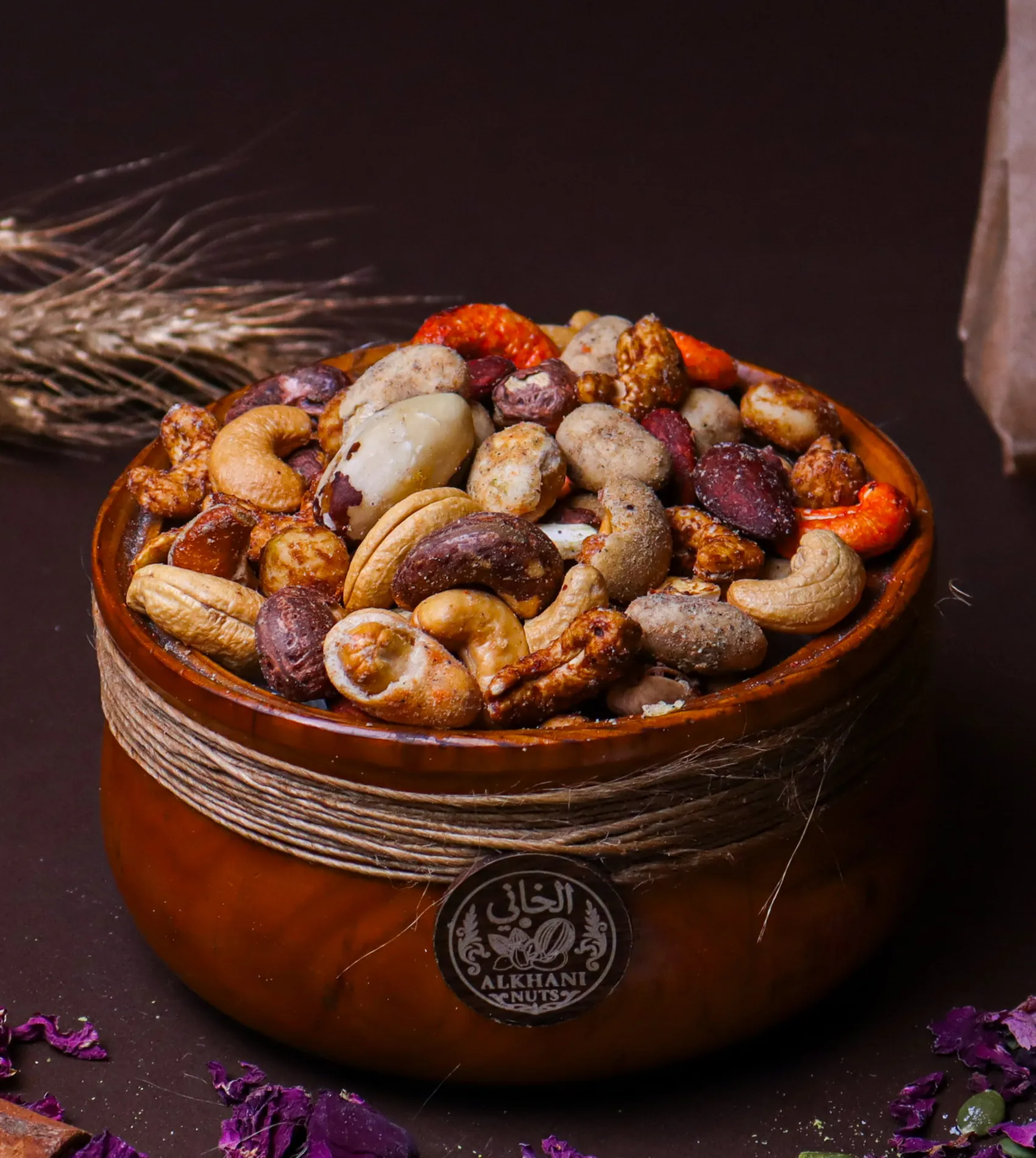 كرزات مشكّلة متبّلة فيها كاجو أحمر وحبات مغلّفة ومبهّرة ولوز غامق بزبدية خشب ملفوفة بخيط خيش وعليها ختم الخاني