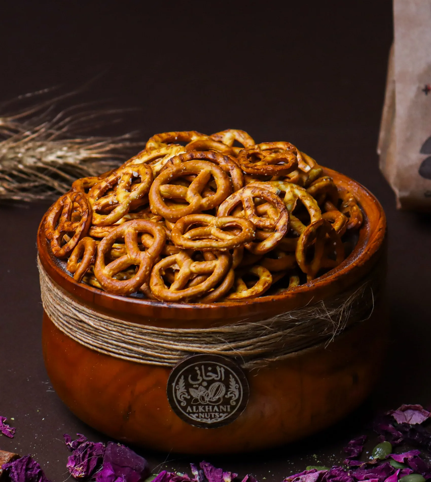بريتزل مملّح، عقد صغيرة دهبية عليها حبيبات ملح، بزبدية خشب ملفوفة بخيط خيش وعليها ختم الخاني